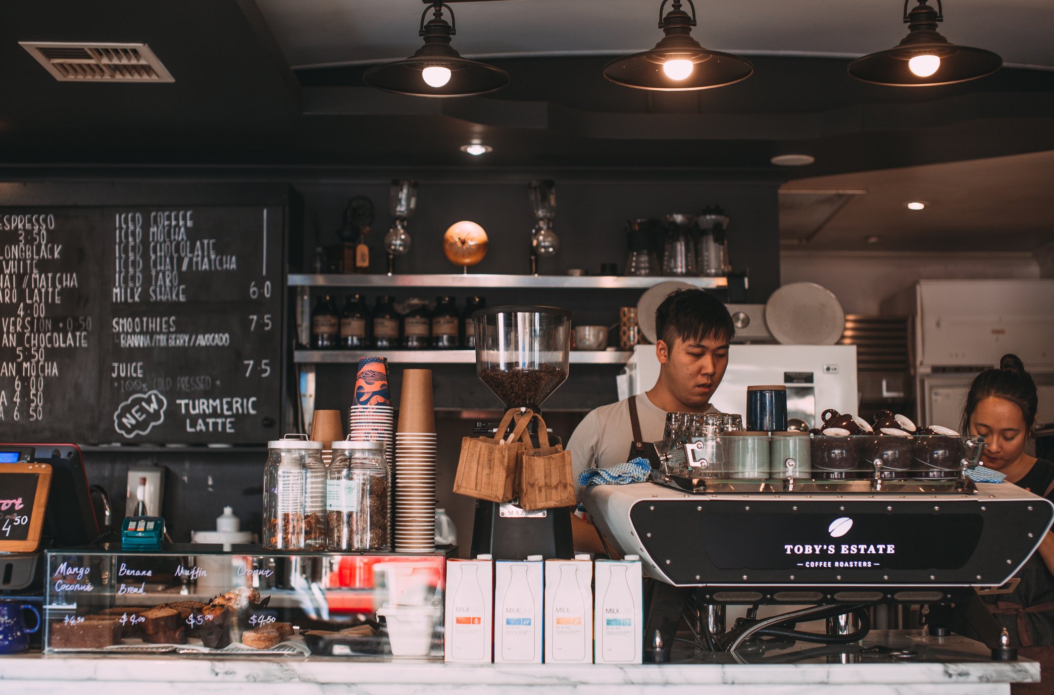 Man and Woman Bartenders at Coffee Shop Counter