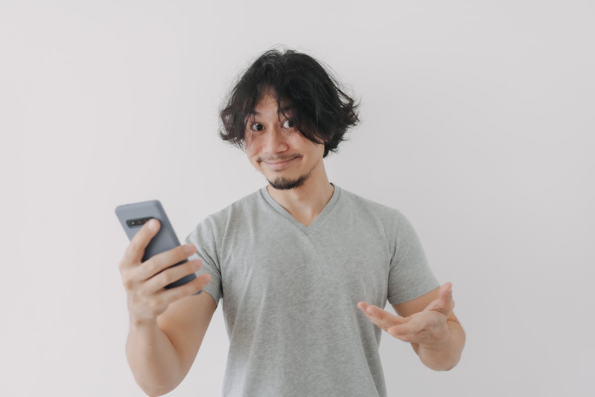 Funny and Happy Face of Man Look at His Smartphone on White Background.