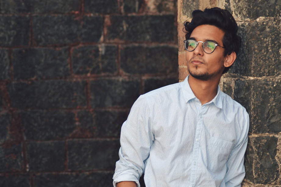 Man Leaning on Black Brick Wall