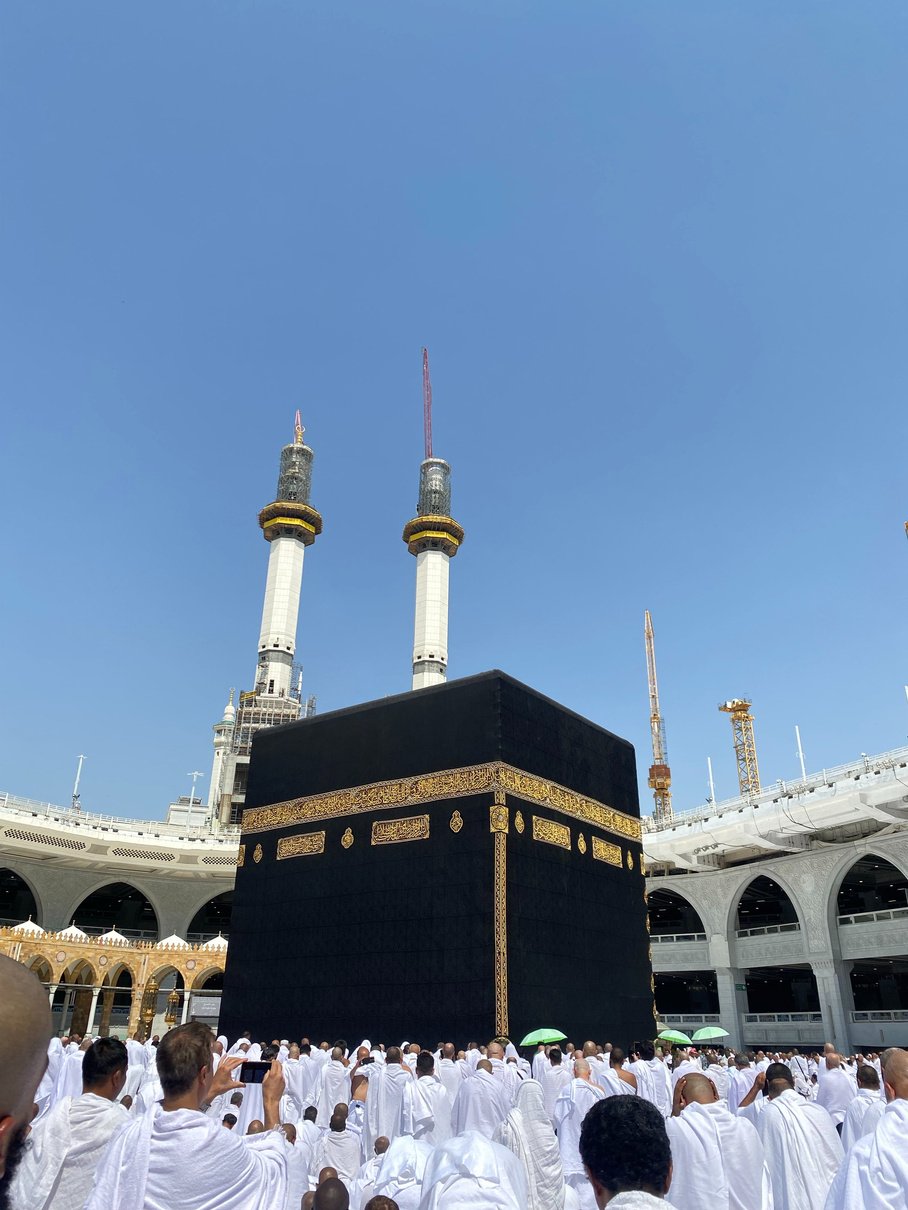 People are standing around the kaaba in the middle of a crowd