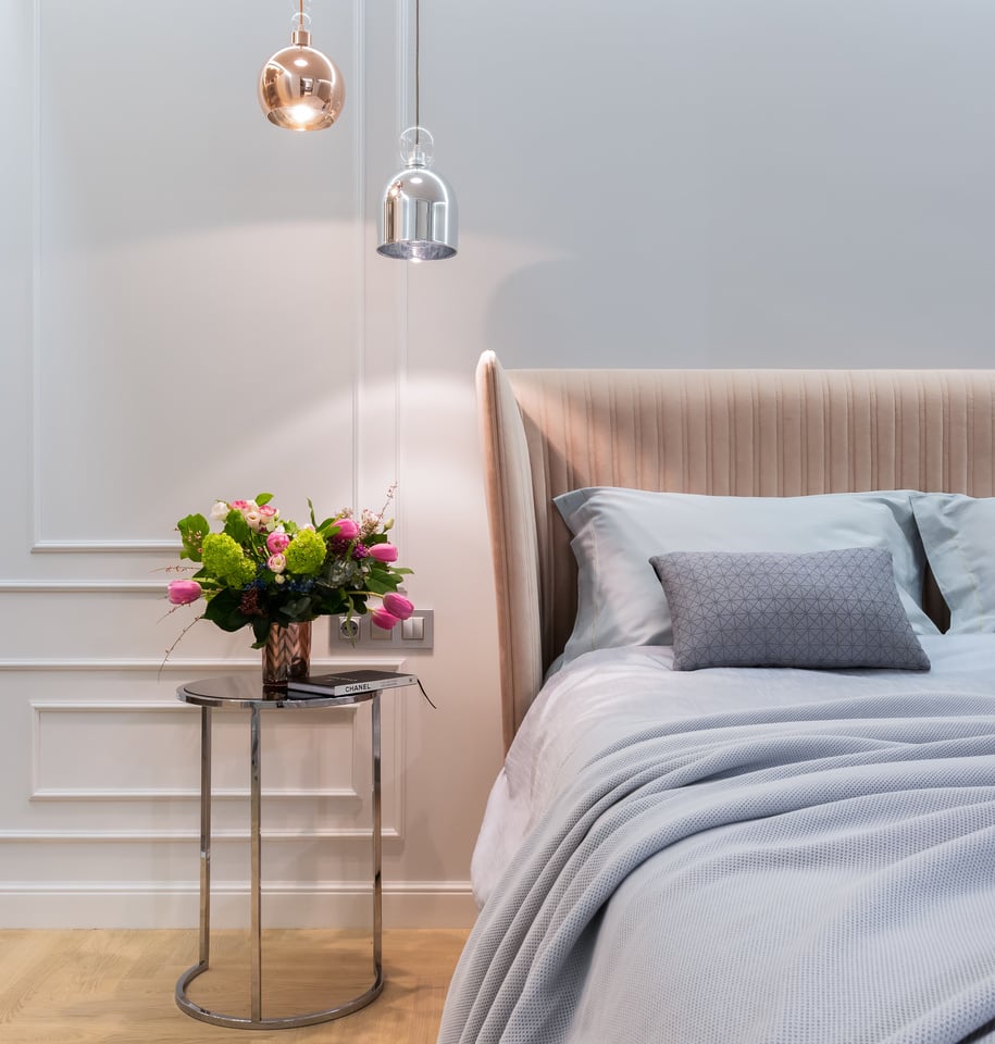 Apartment interior with bed near table with flowers in vase