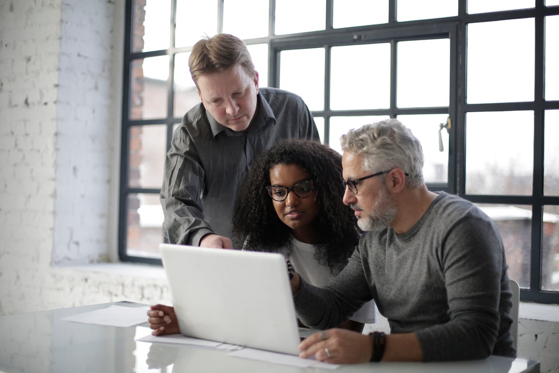 Focused business team with laptop discussing project